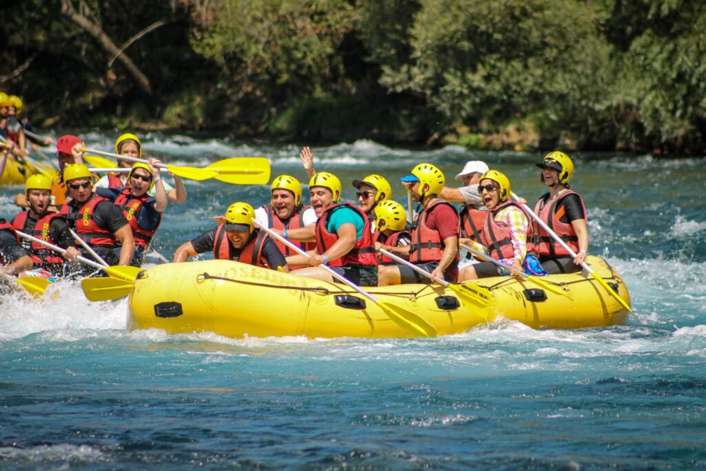 Home Energetic group enjoying a rafting adventure on river rapids with teamwork and fun.