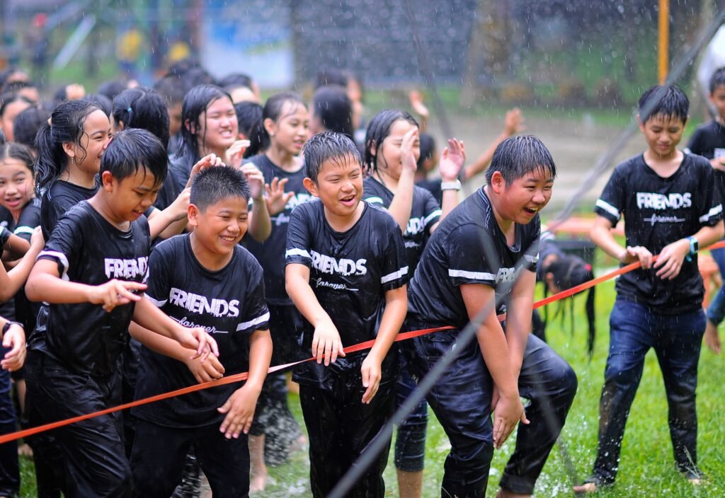 Home Group of wet and happy children enjoying rain during outdoor fun.